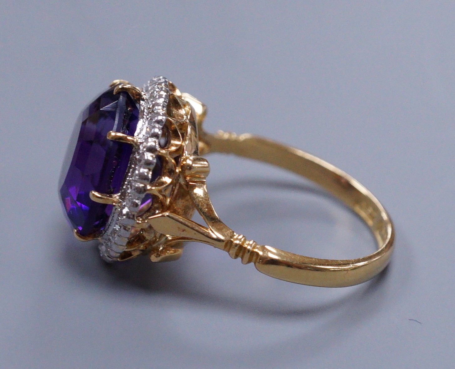 An 18ct gold and platinum, amethyst and diamond circular cluster ring, size M, gross 5.7 grams